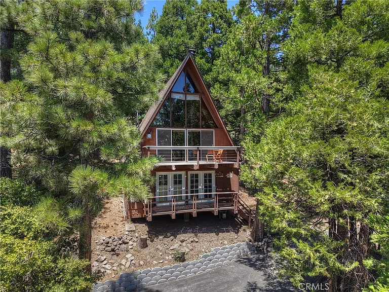 A-frame cabin nestled amongst the trees. $195,000